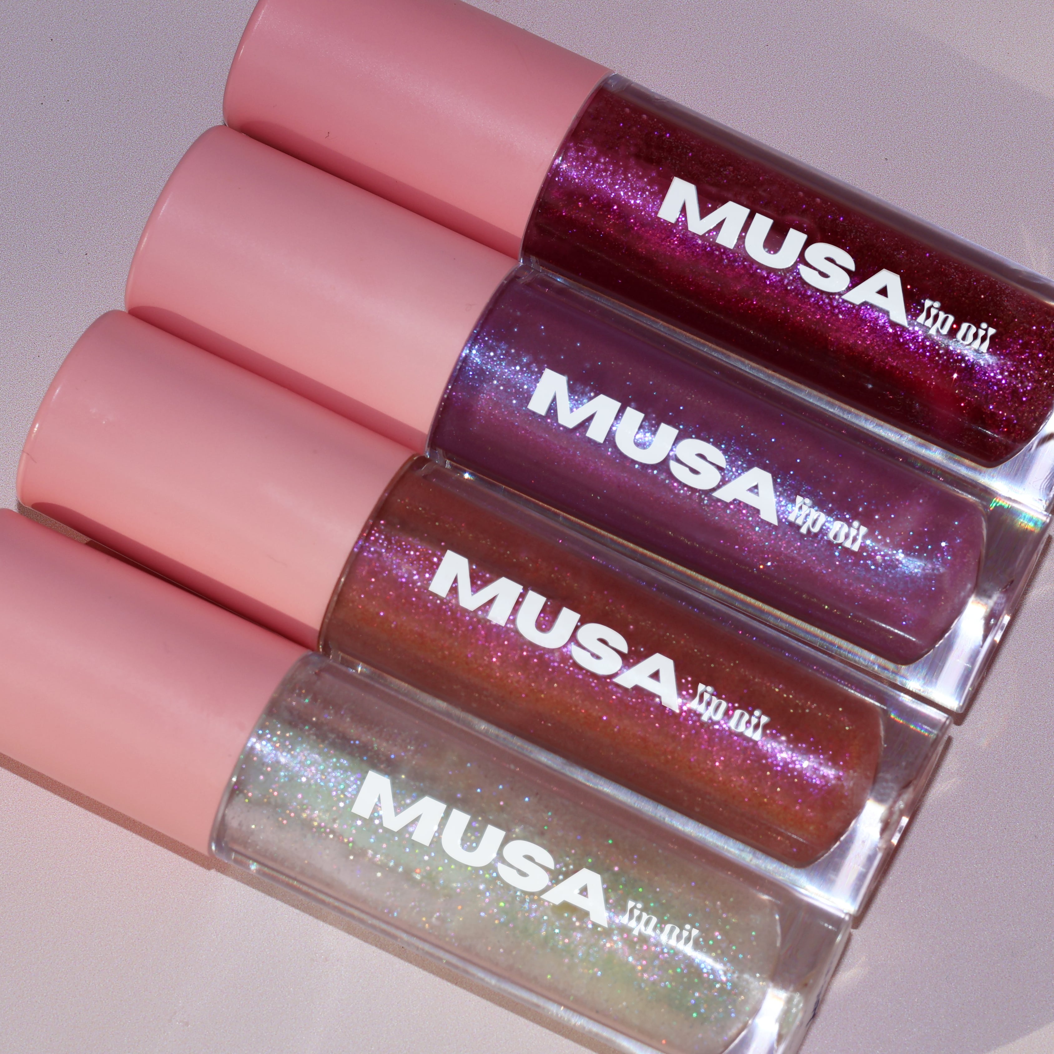 Glitter Lip Oils from Musa Glitter. One Holographic lip oil, one pink lip oil, one purple lip oil and one red lip oil.