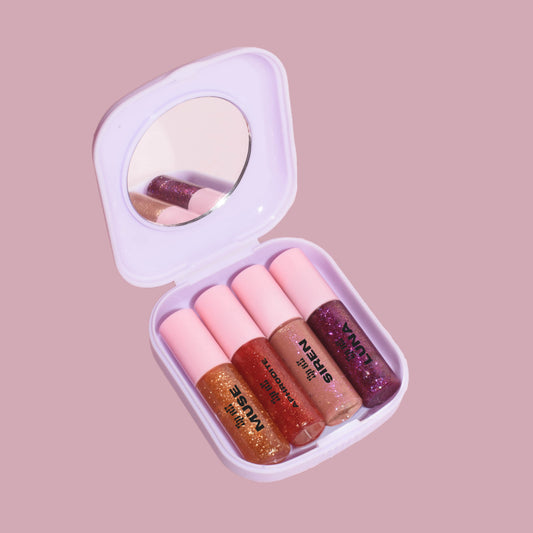 A travel size case with four glitter lip oils. This box contains a gold glitter lip oil, a red glitter lip oil, a pink glitter lip oil and a purple glitter lip oil